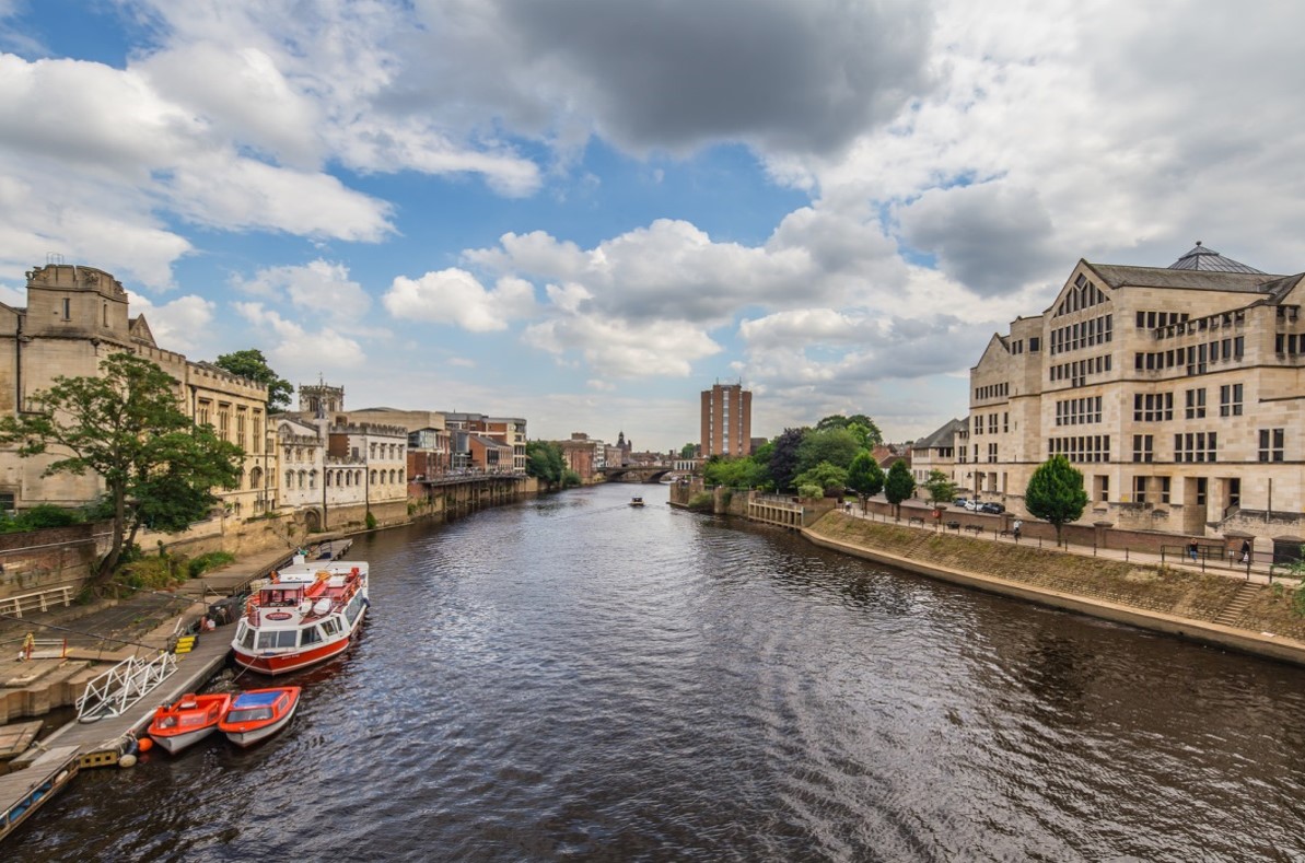 Looking down the river in York with buildings on either side of the banks