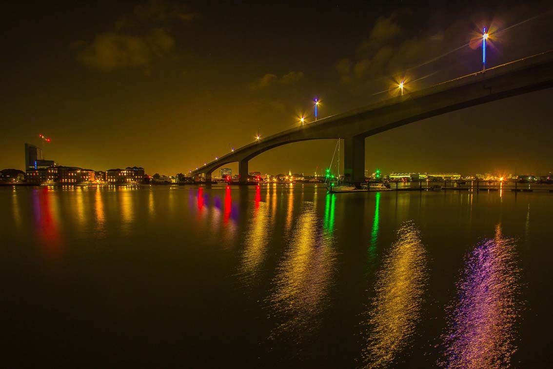 View of Southampton at night, showing the water and a bridge