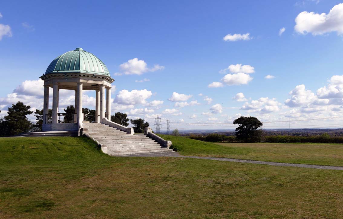 Pavillion in a green grassy park with blue sky