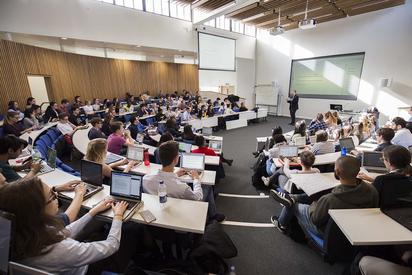Back view of a lecture hall overlooking students attending a lecture