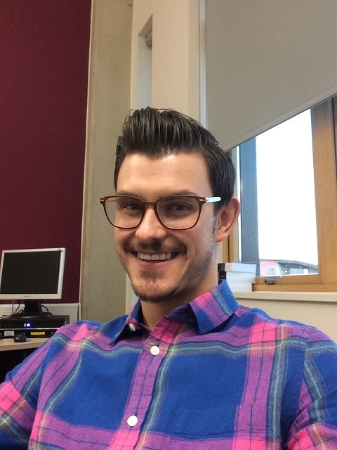 Headshot of Zachary wearing glasses and plaid shirt