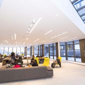 Inside view of a study lounge at a university with students on couches