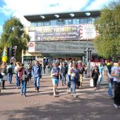 View of campus building with lots of people walking in front