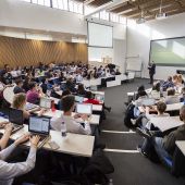 Back view of a lecture hall overlooking students attending a lecture