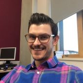 Headshot of Zachary wearing glasses and plaid shirt